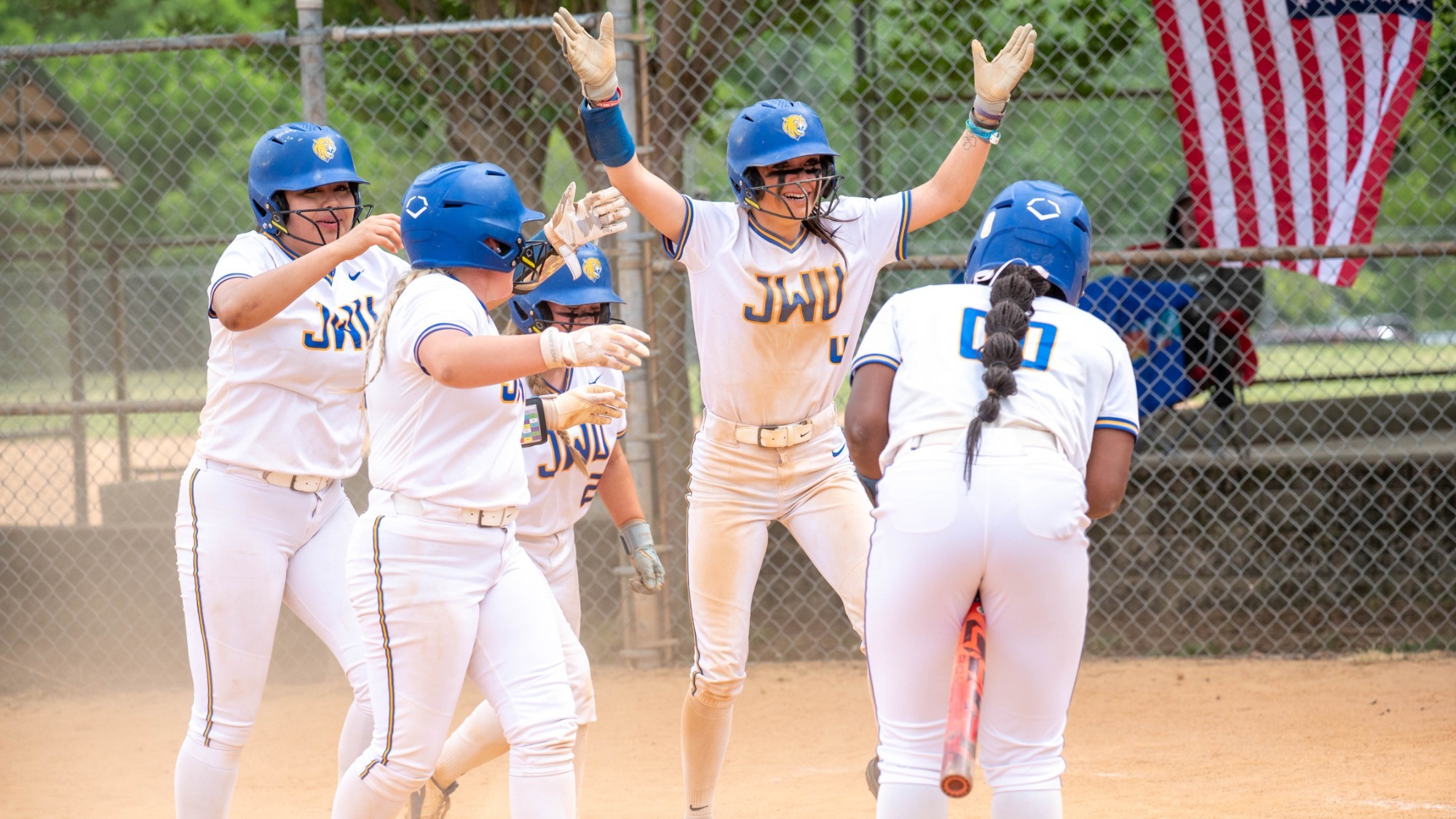 women celebrating after scoring runs in softball