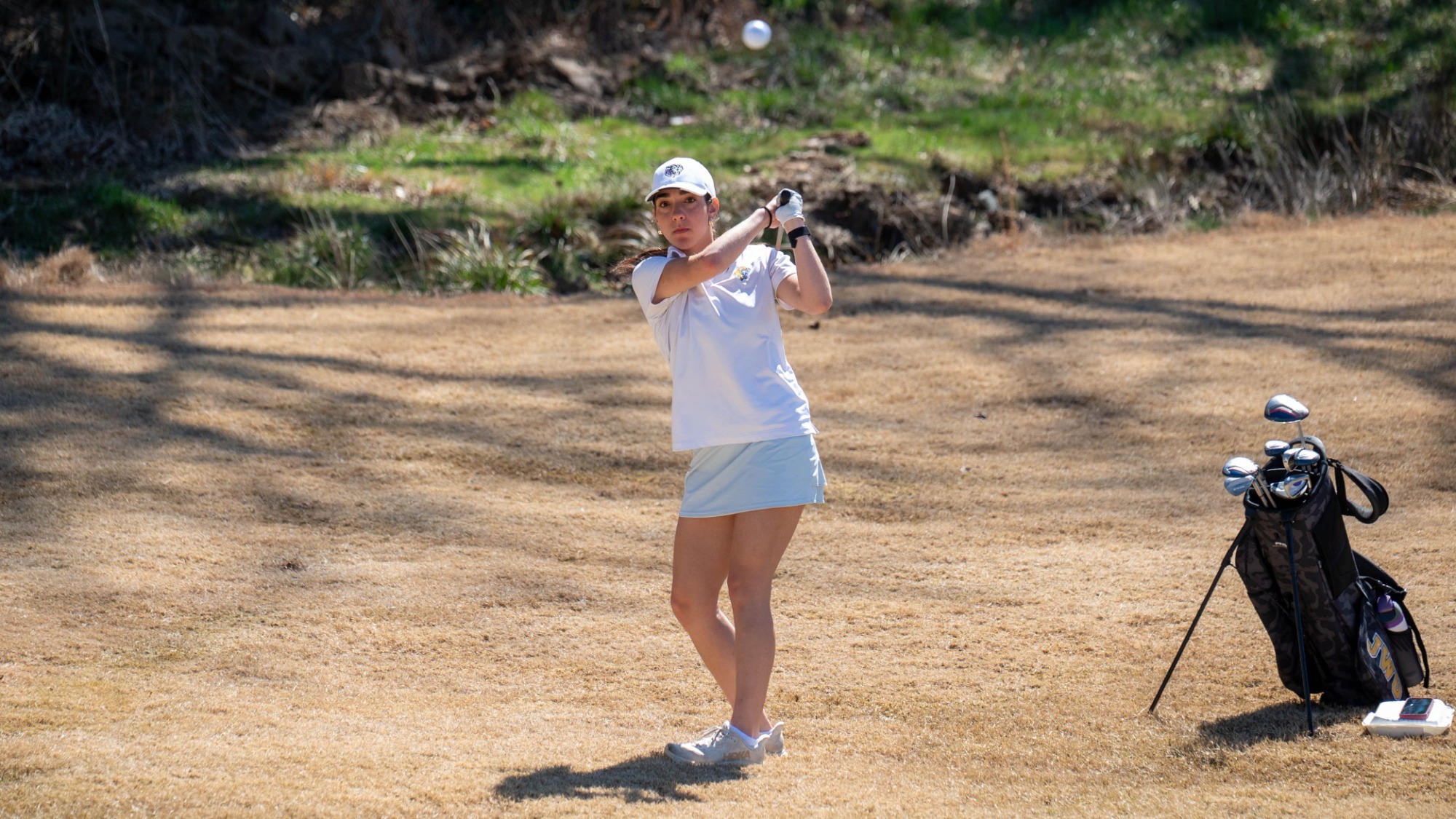 woman hitting a golf ball