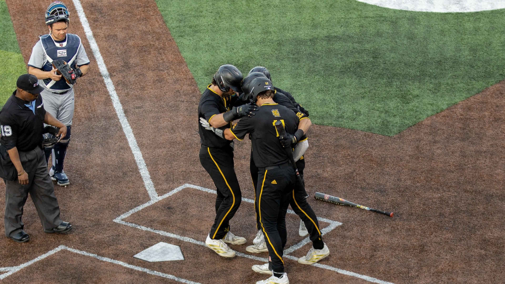 KSU players hug at home plate after a homer