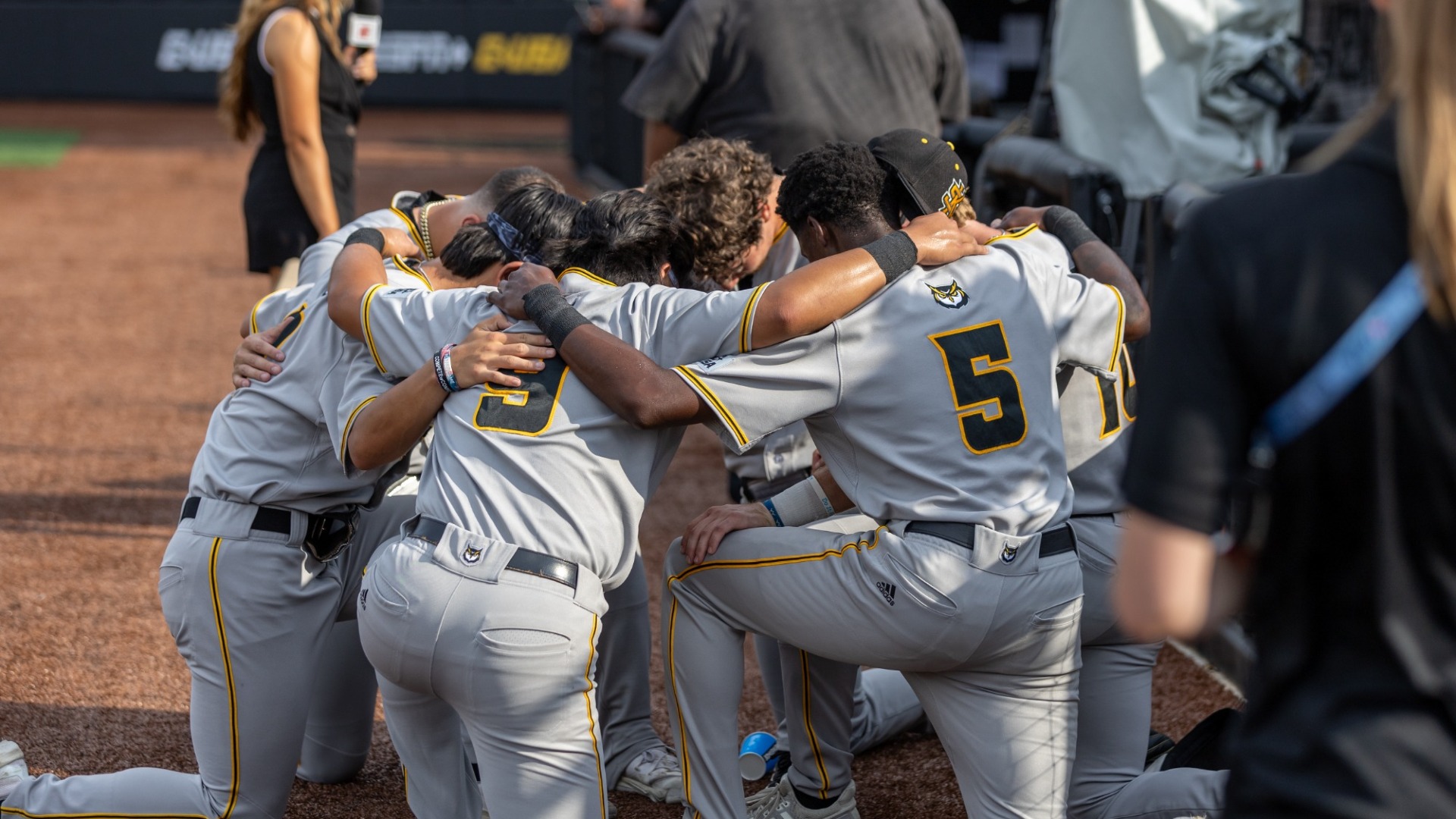 Baseball players praying before Wednesday's CUSA Championship game