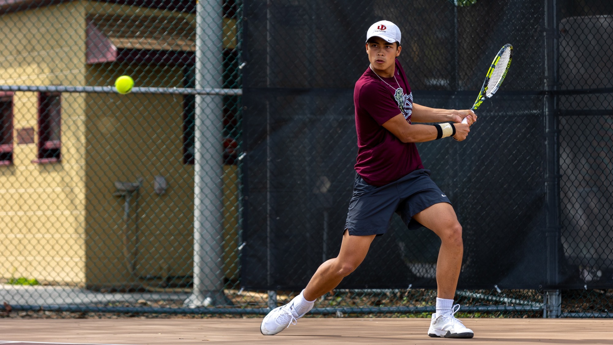 Dang Nguyen of the Kutztown University men's tennis team hits a backhand shot in a PSAC match against West Chester on April 22, 2025.