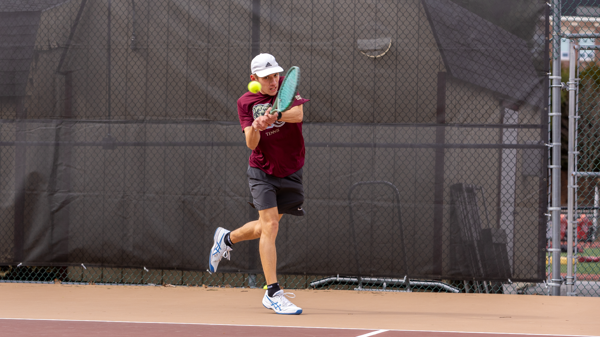 Linus Vennekold of the Kutztown University men's tennis team hits a backhand shot during a doubles match against Marymount (Va.) on March 26, 2025.