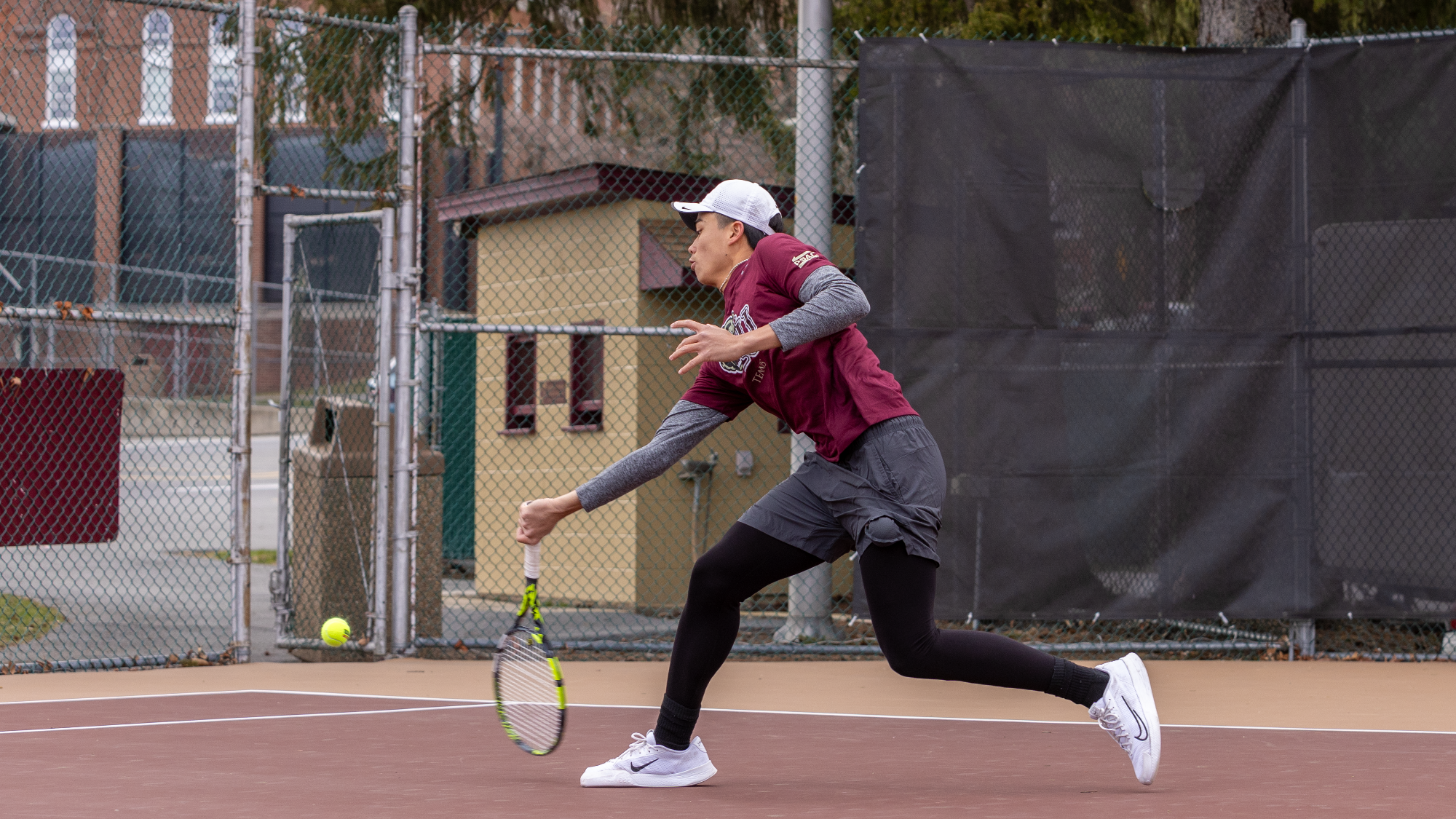 Dang Nguyen of the Kutztown University men's tennis team hits a shot on the run in a doubles match against Marymount (Va.) on March 26, 2025.