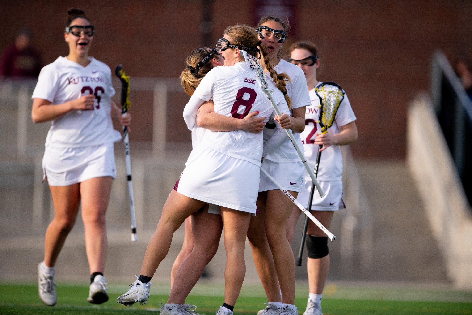 Team hugs #8 Sam Graf after scoring vs Bentley