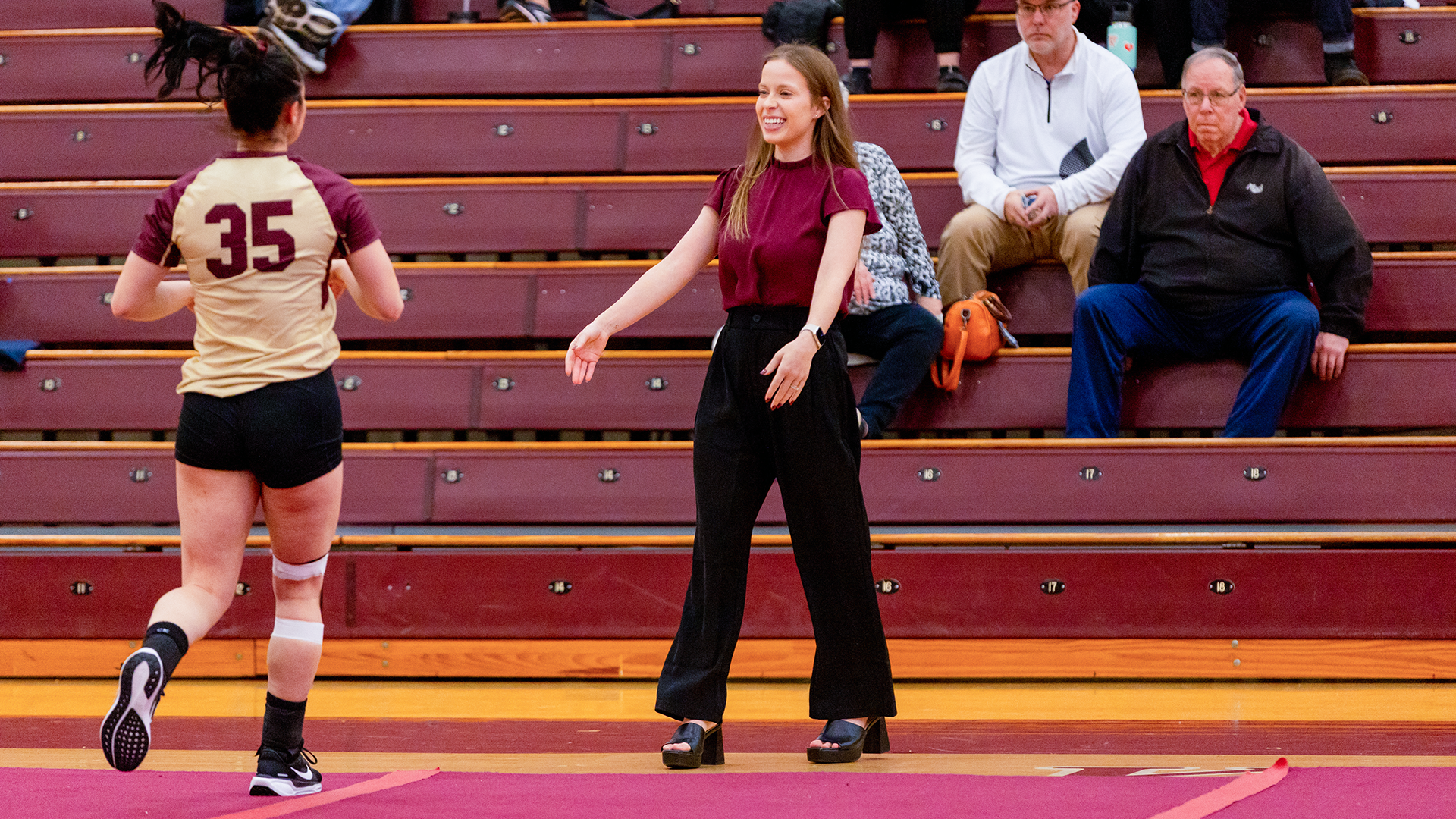 Head coach Karah Paull congratulates one of her athletes during a collegiate acrobatics & tumbling meet against Stevenson on Feb. 27, 2025.