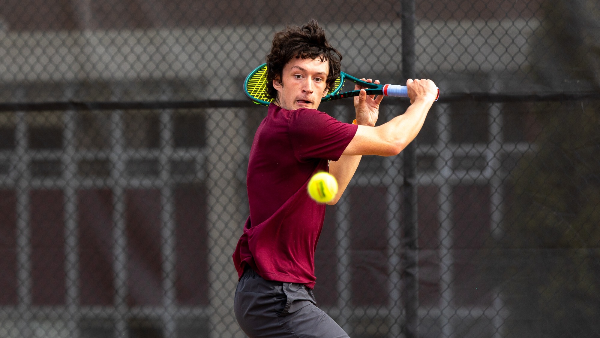 Emmitt Robinson of the Kutztown University men's tennis team hits a backhand shot during a match against West Chester on April 22, 2025.