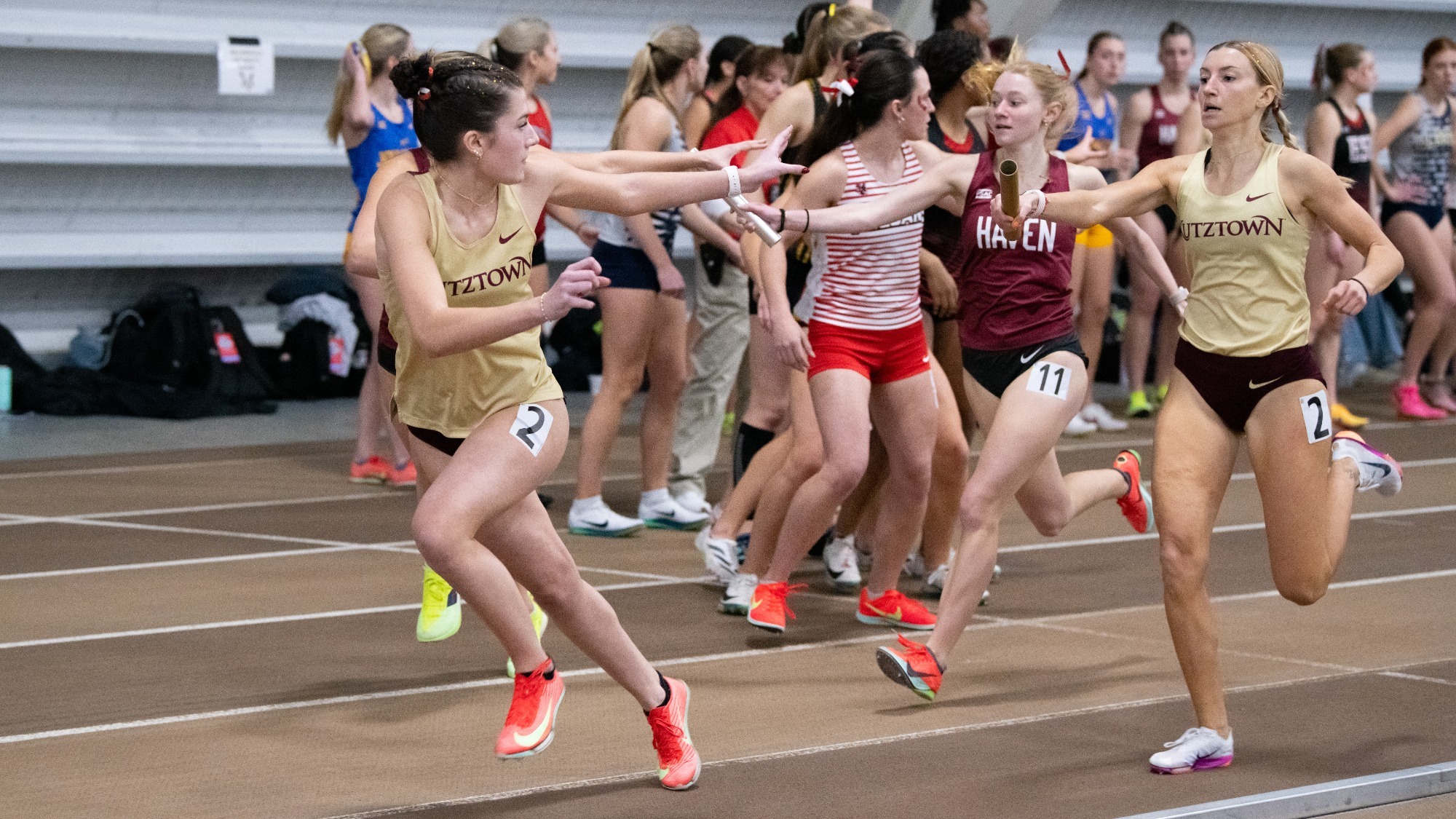 Mackey Donovan of the Kutztown University women's track & field team transfers the baton to teammate Isabella Hughes during the distance medley relay at the PSAC Indoor Championships on Saturday, Feb. 28, 2026. The Golden Bears won the bronze medal in the event.