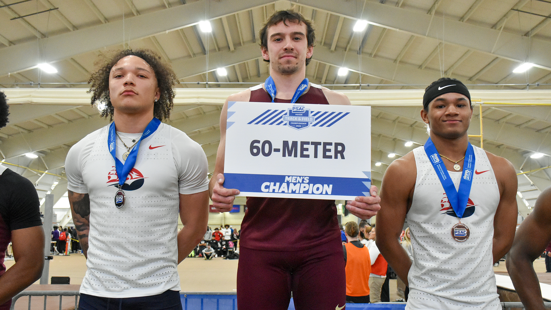 Michael Fellin of the Kutztown University men's track & field team stands atop the podium after winning his second straight 60-meter dash title at the PSAC Indoor Championships on Sunday, March 1, 2026. 