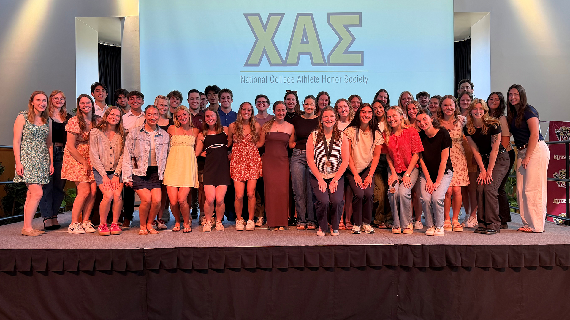 Chi Alpha Sigma 2026 inductees on stage following luncheon