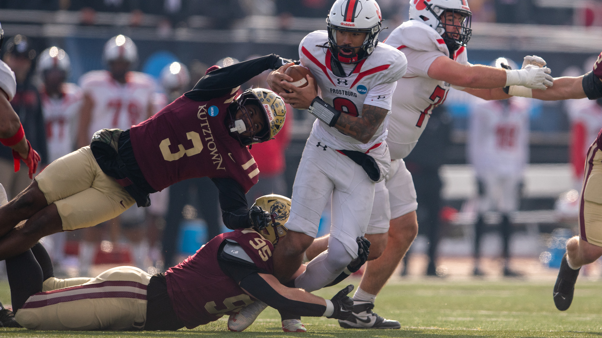 Eden Johnson (3) and Freddie Retter (95) of the Kutztown University football team attempt to tackle Frostburg State's quarterback during the NCAA Division II national quarterfinals on Saturday, Dec. 6, 2025.