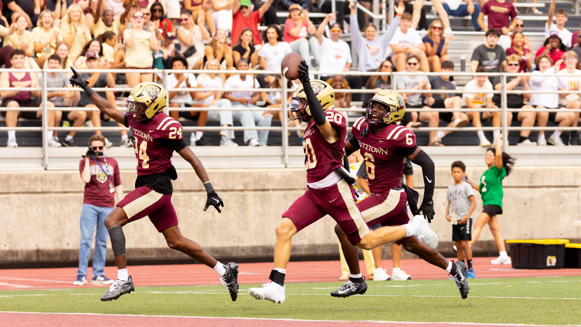 Michael LeMay (20) of the Kutztown University football team returns a blocked punt for a touchdown during the second quarter of the Golden Bears' 45-14 victory over Clarion at Andre Reed Stadium on Saturday, Sept. 12, 2026. Teammates Trey Hamlin III (24) and Zach Perta (6) celebrate the return alongside LeMay.