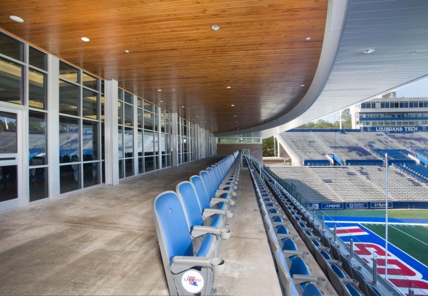 Rows of padded outdoor DAC chairback seats overlooking the football field