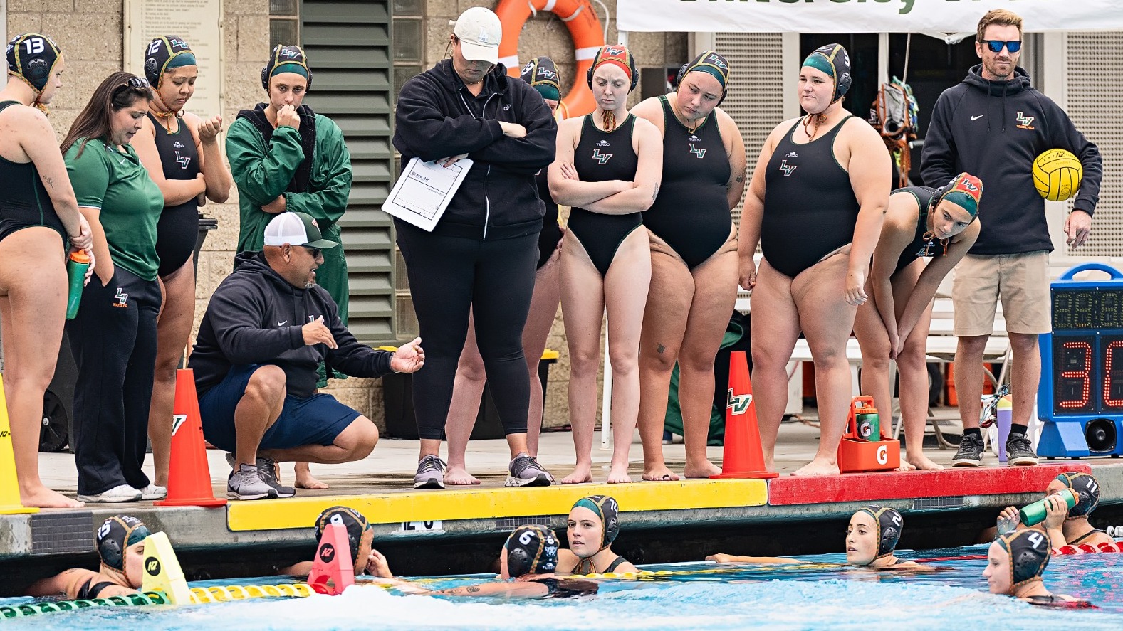The Leopards women's water polo team gather at a timeout.