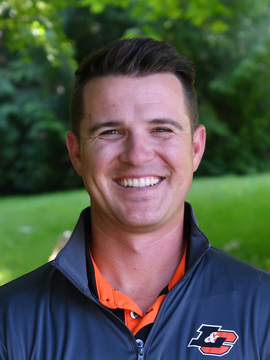 Brad Breier stands in front of a green background smiling