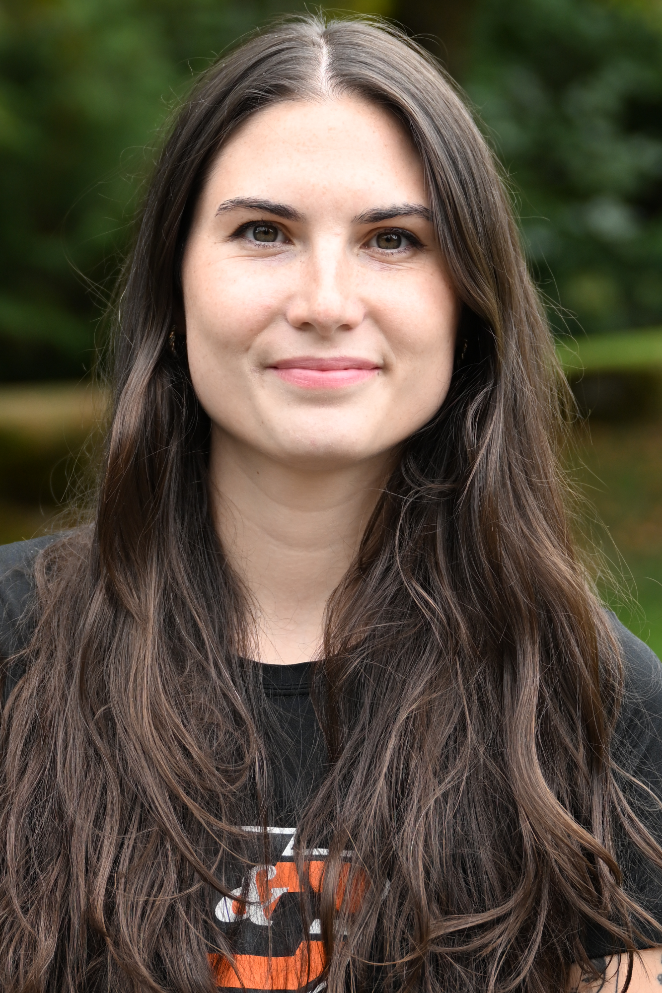 Sarai Seekamp smiles in front of a green background