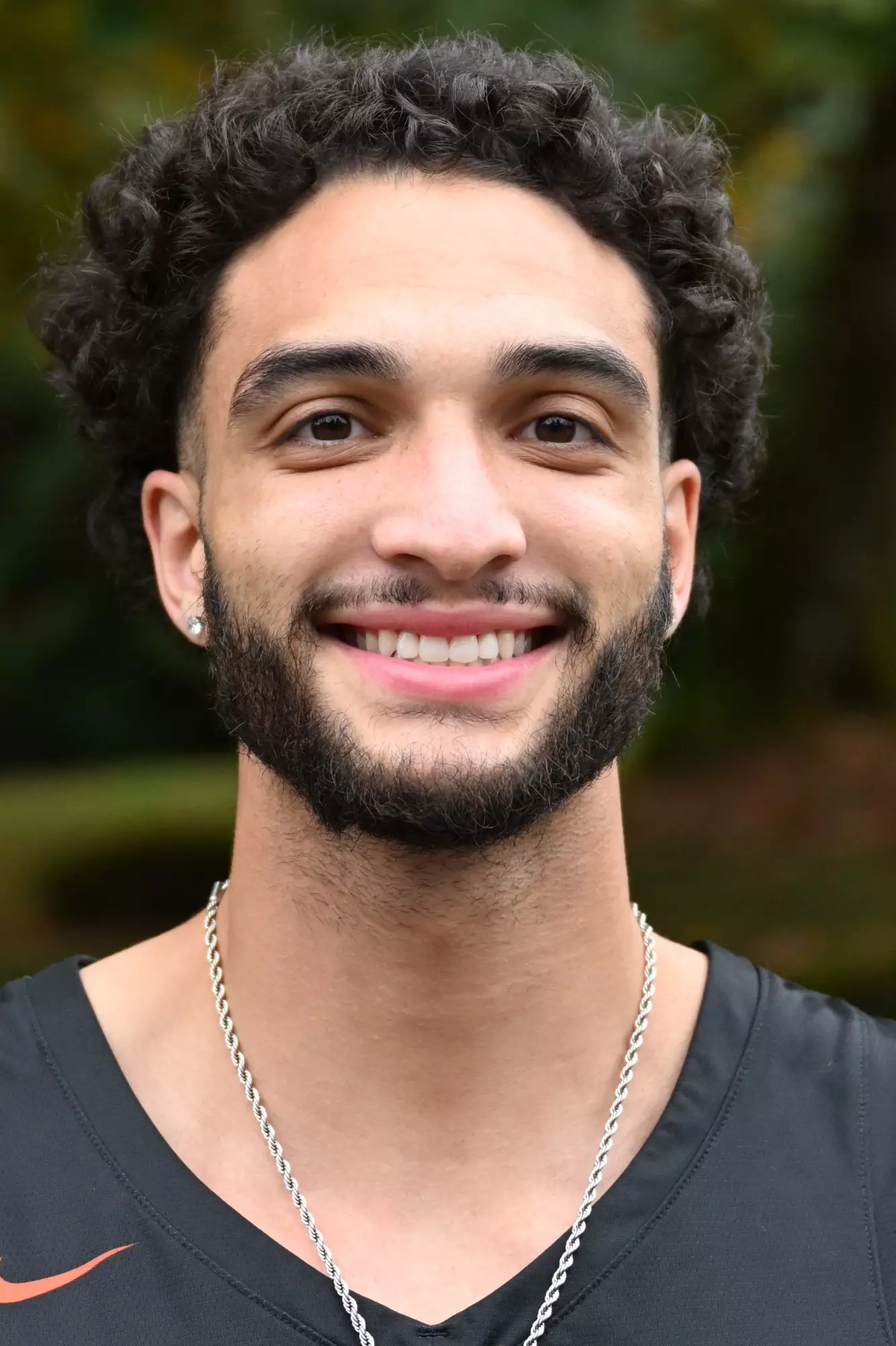 Andre Treadwell smiles in front of a green backdrop