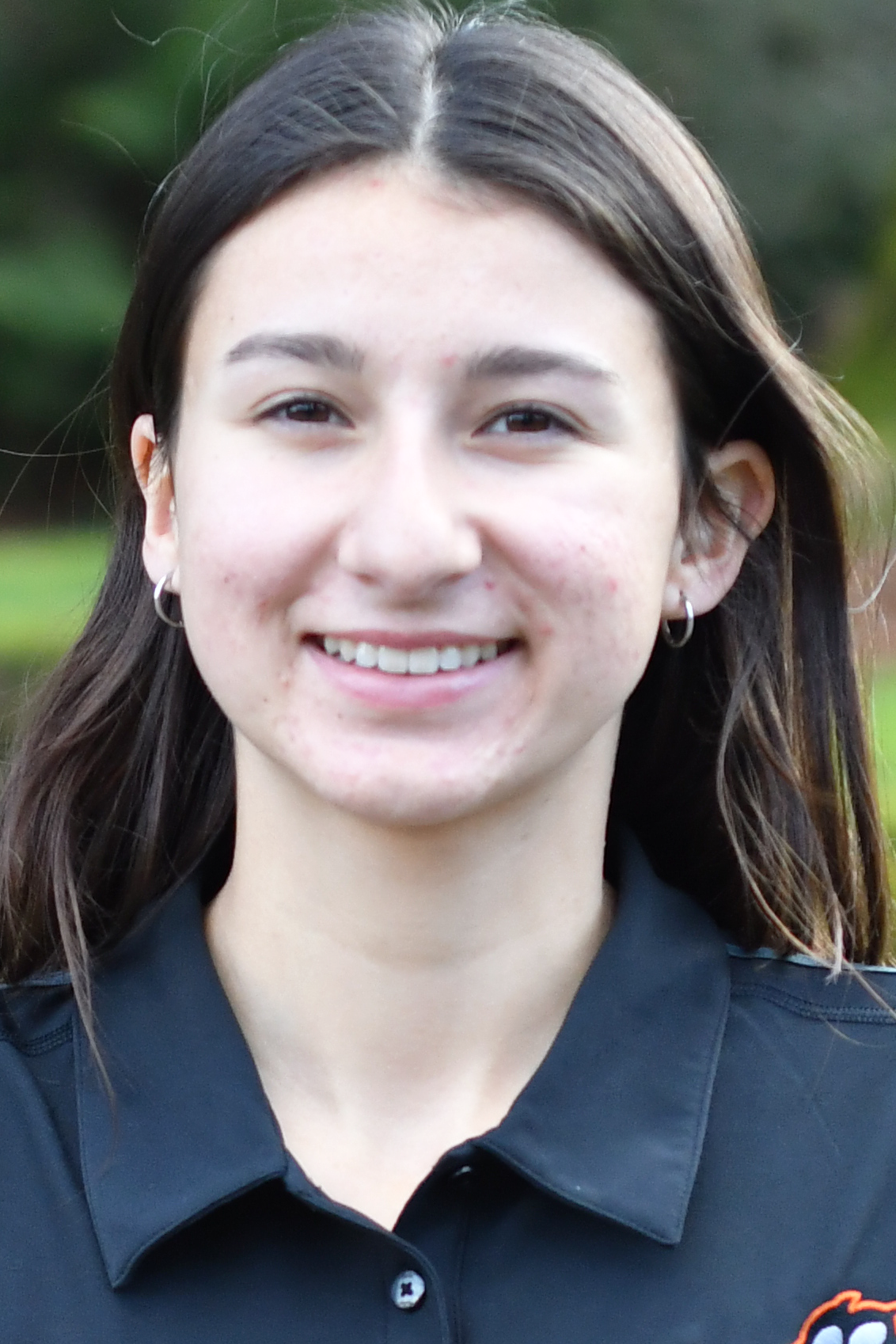 Ellie Crema smiling in front of a green background