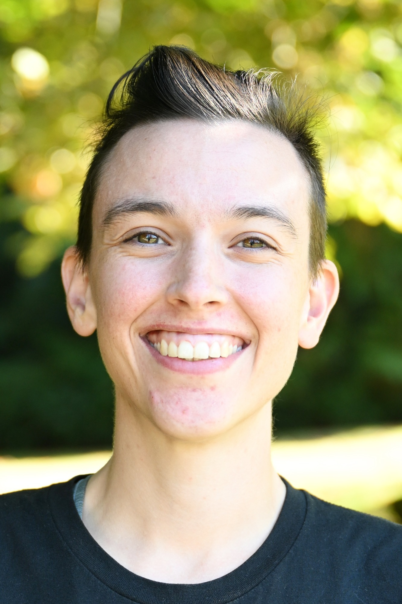 Charlotte Copp stands in front of a green background, smiling.