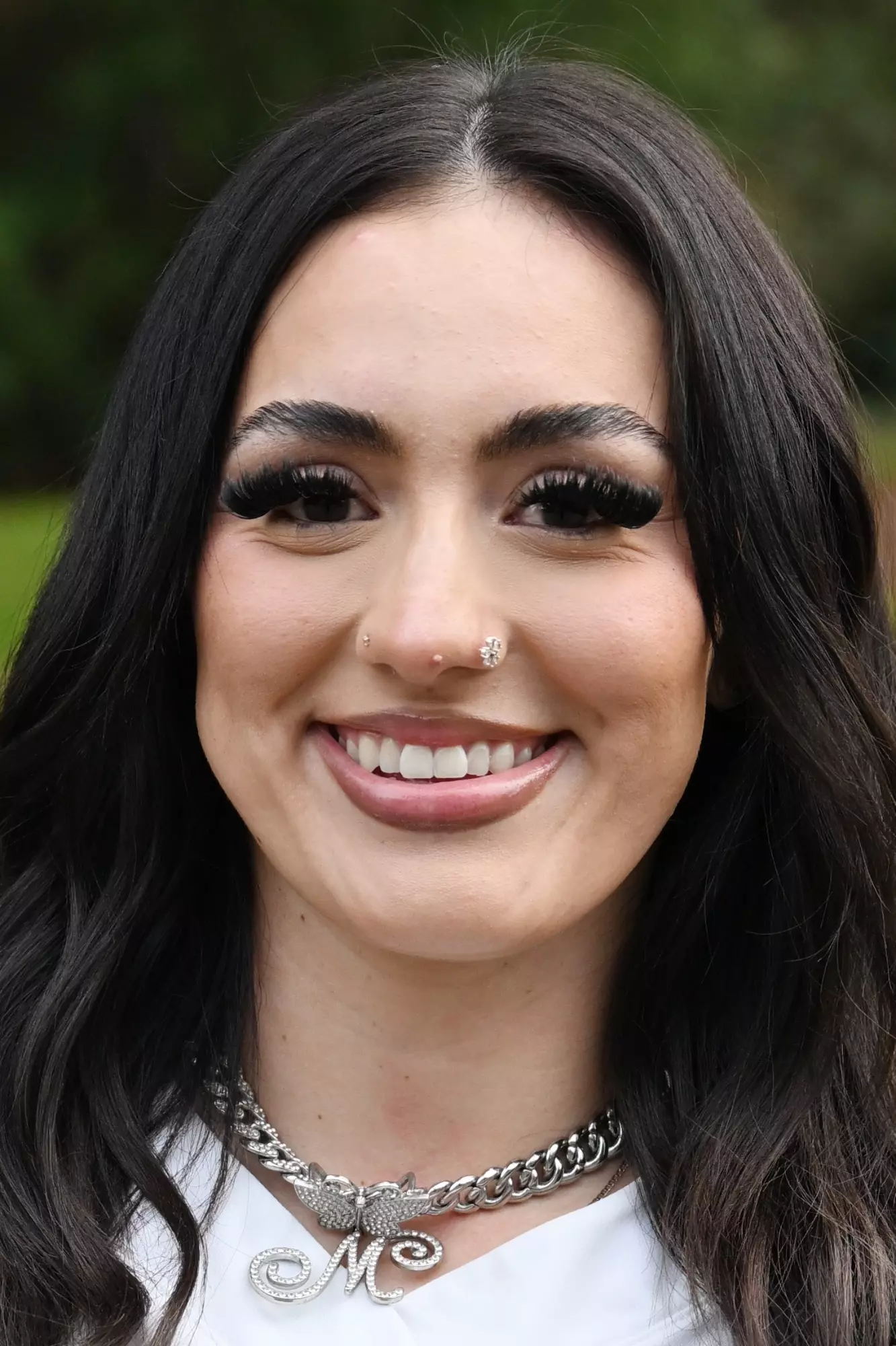 Mari Alvarez smiles in front of a green background