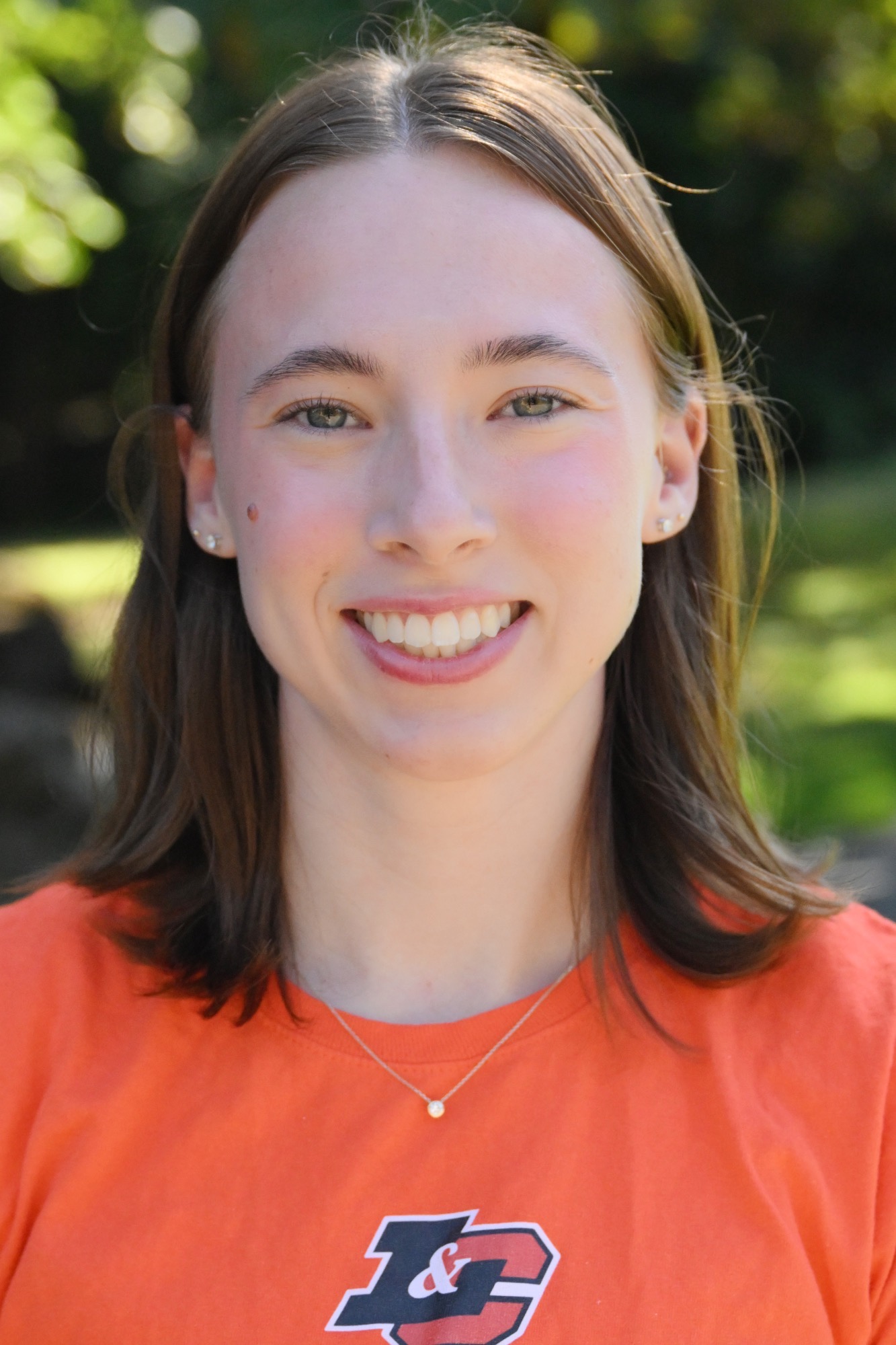 Joan Grant smiles in front of a green background 