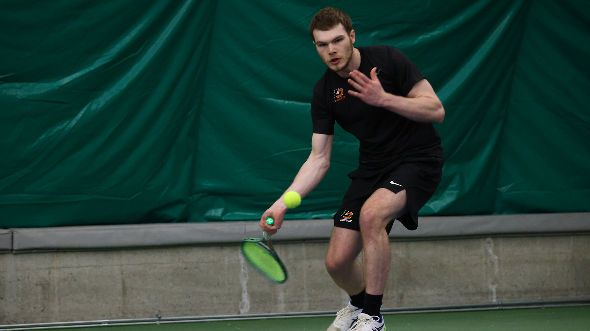 Max Furman hits a baseline forehand. 