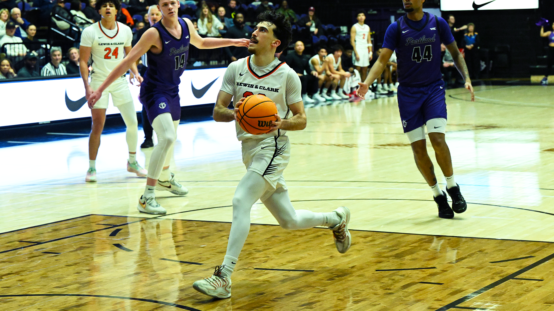 Yigit Arcan dribbles to the basket ahead of a defender. 