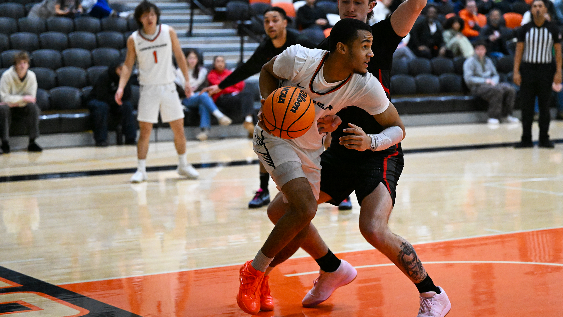 Donovan Beard dribbles past a defender under the basket. 