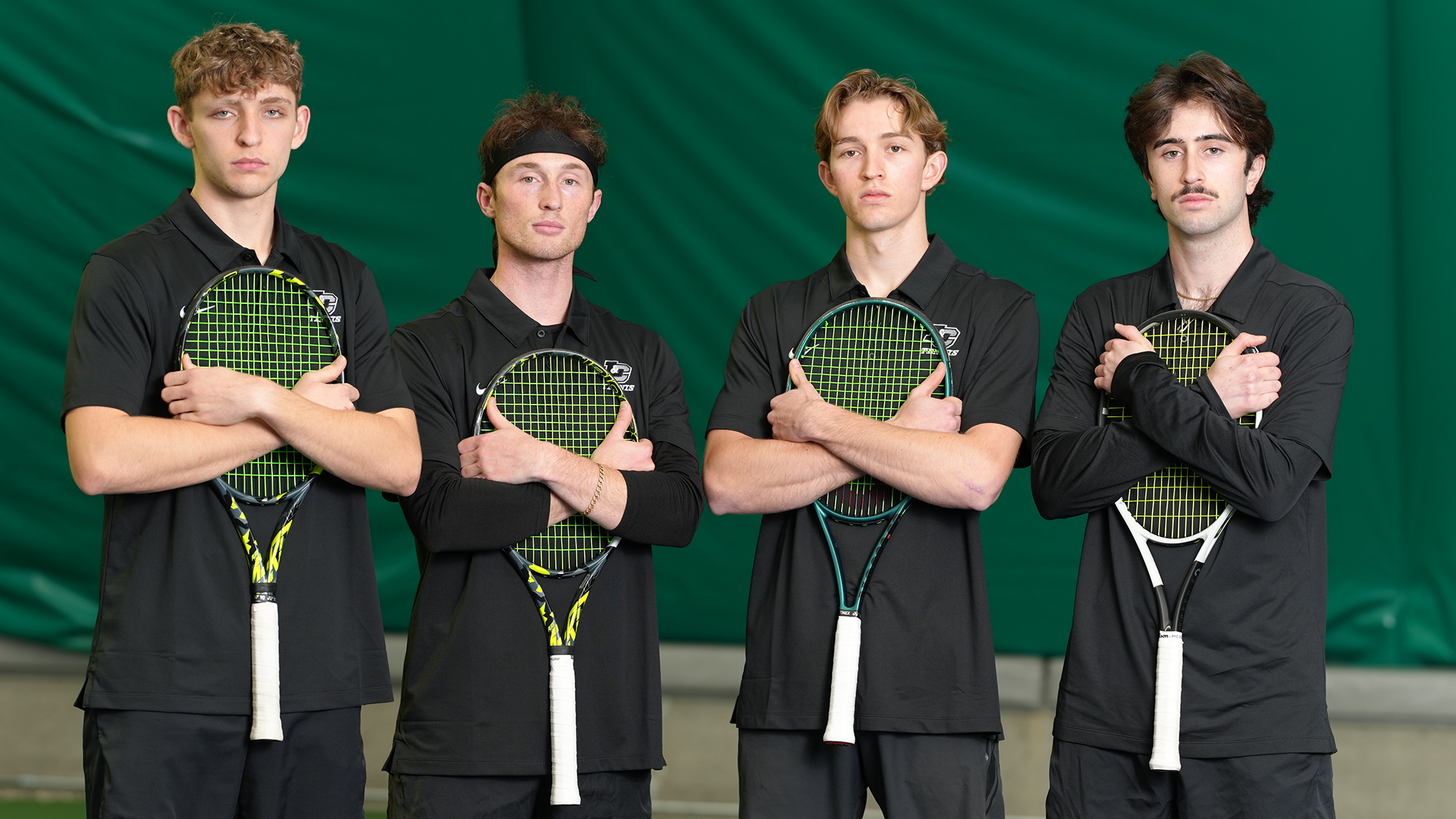 Spencer Loucks, Kai Wills, Wade McDermott and Landon Cronin stand in a line hugging their tennis rackets. 