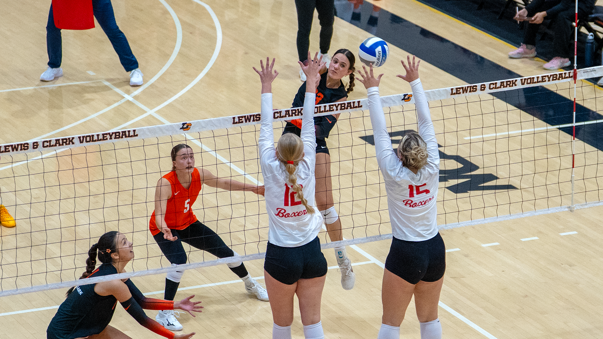 Lexi Musselwhite hits a ball against two blockers.