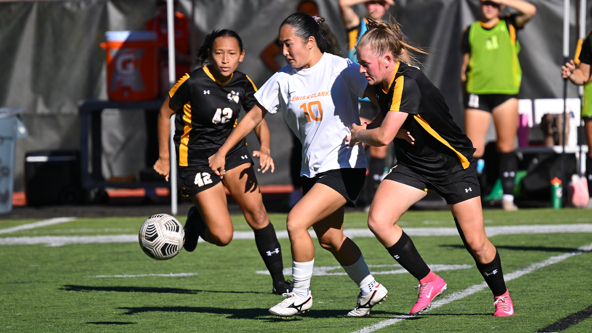 Tatum Akimoto-Albarado fights for the ball between two defenders