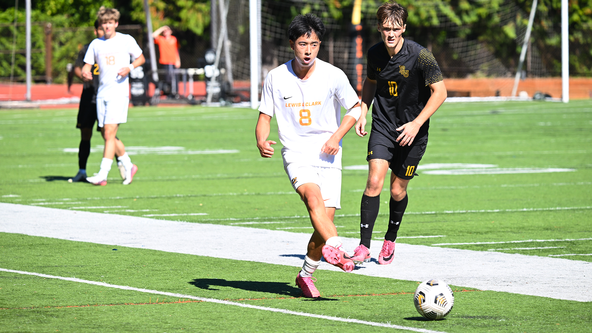 Kaden Nakamura kicks the ball against a Pacific Lutheran defender. 