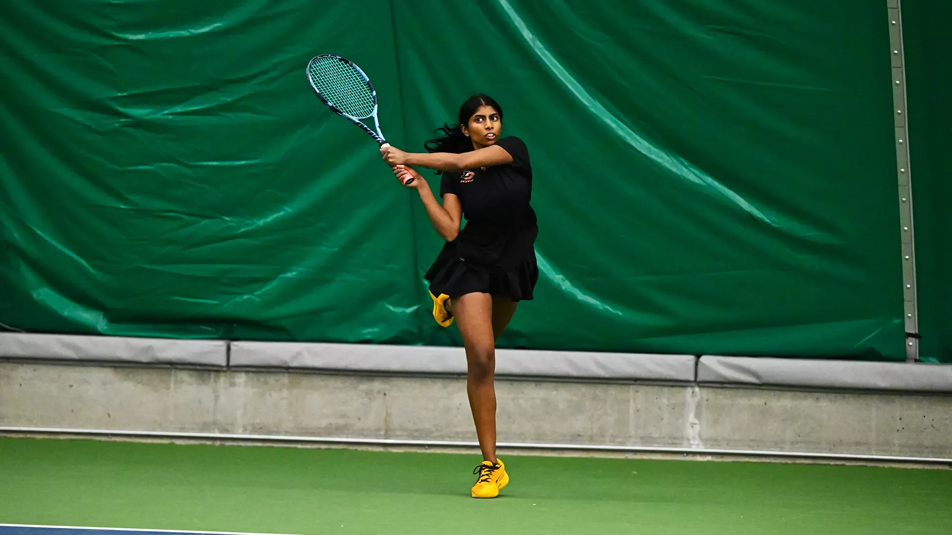 Susanna Anand hits a baseline backhand. 