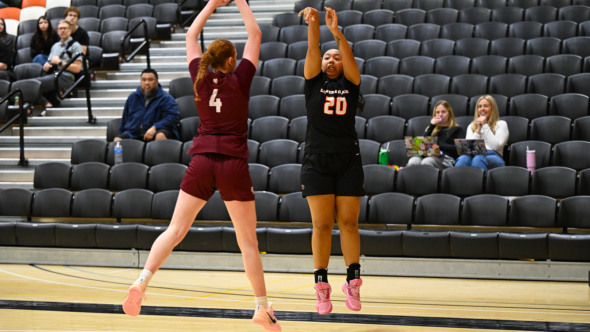 Ky Roussin shoots a three against a defender in maroon. 