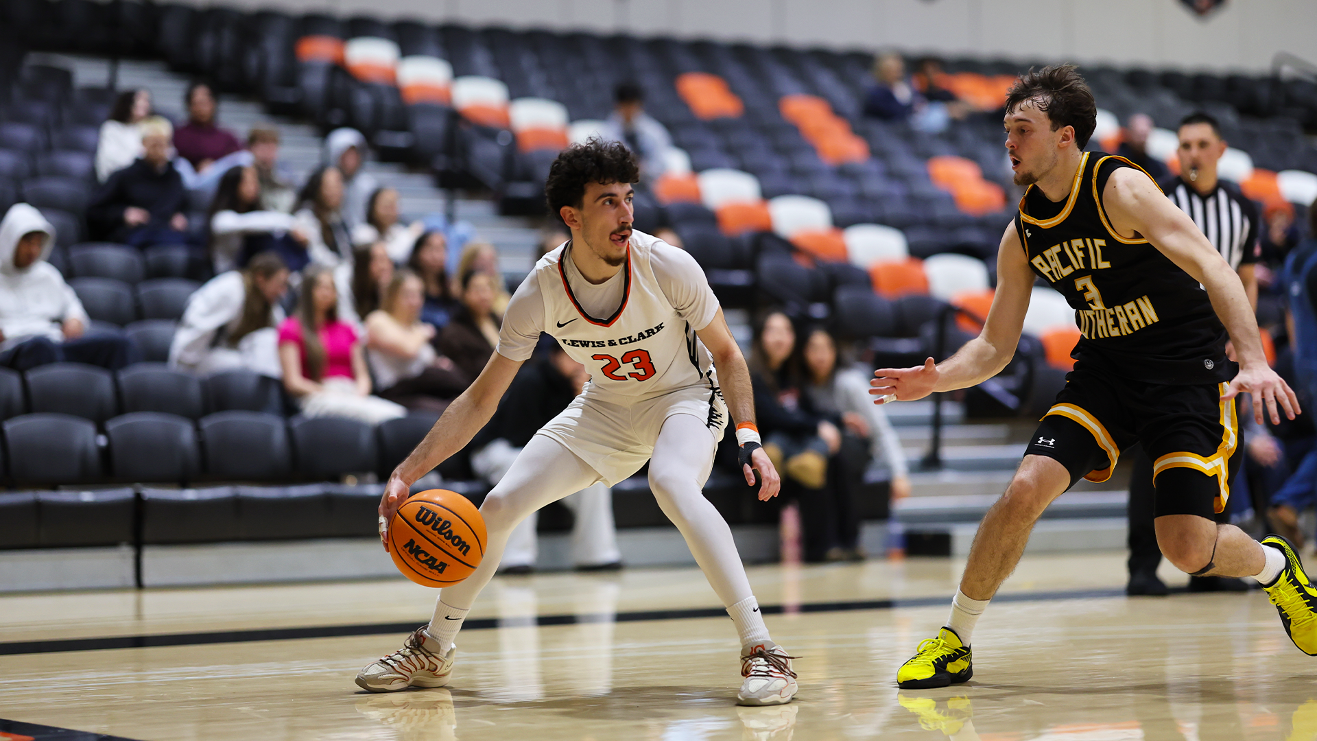 Yigit Arcan dribbles against a defender in black. 
