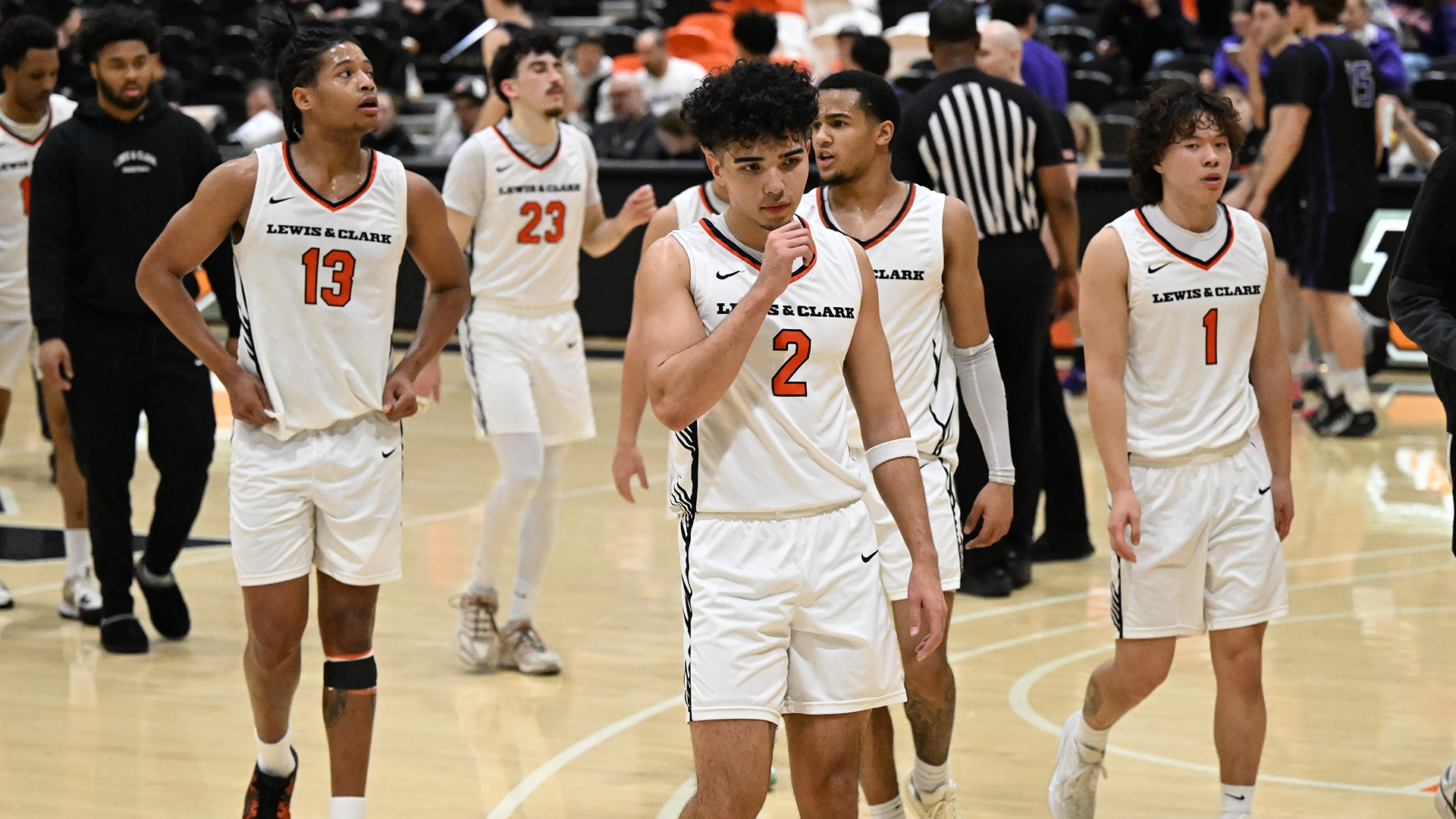 Taien Jackson, Justin White, Donovan Beard, Marcus Bast, and Yigit Arcan walk across the basketball court. 