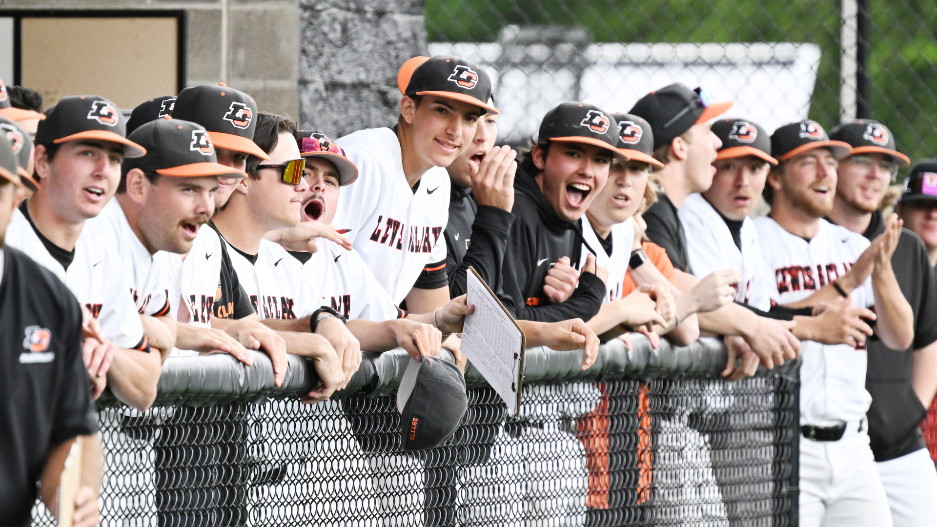 Baseball lines on the railing in their dugout to cheer on the hitter
