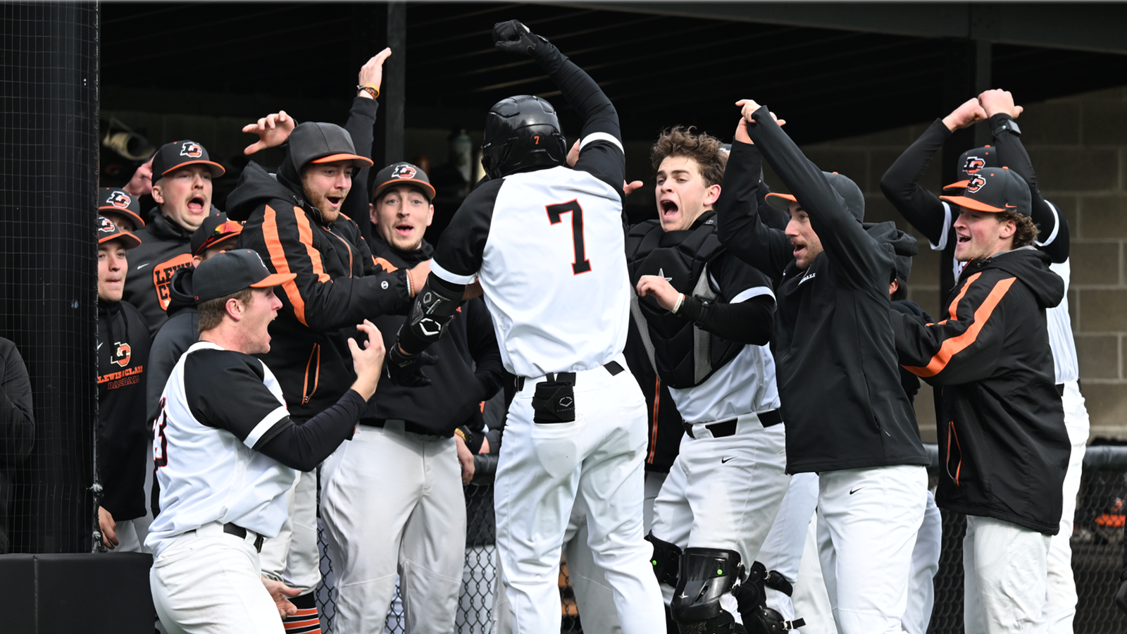 Michael Aikawa and the Lewis & Clark dugout jump up and down and celebrate Aikawa hitting a home run