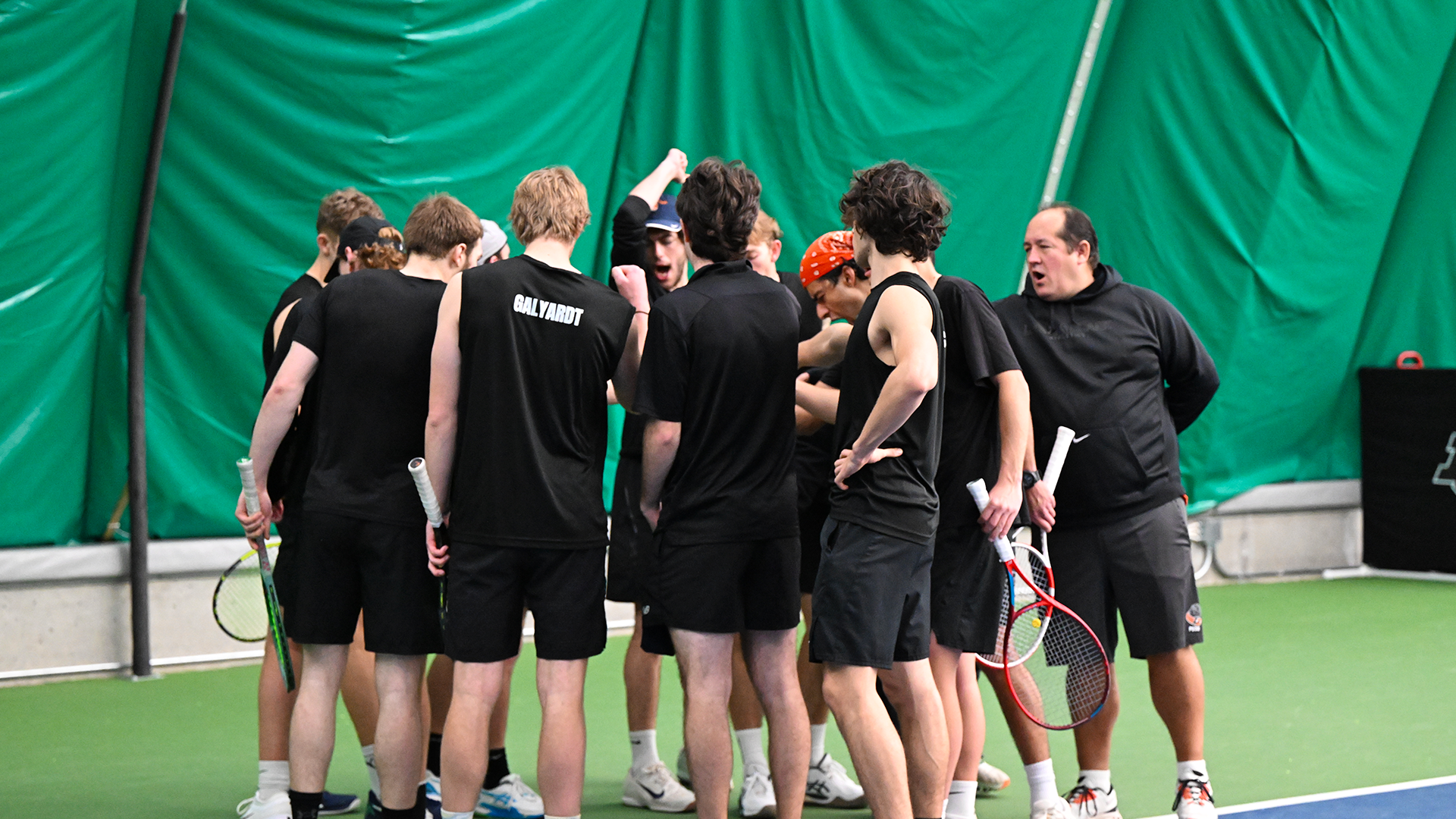 The men's tennis team gathers before a match. 