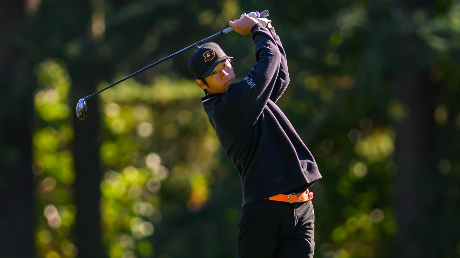 Joonho Moon swings an iron shot and watches the ball fly