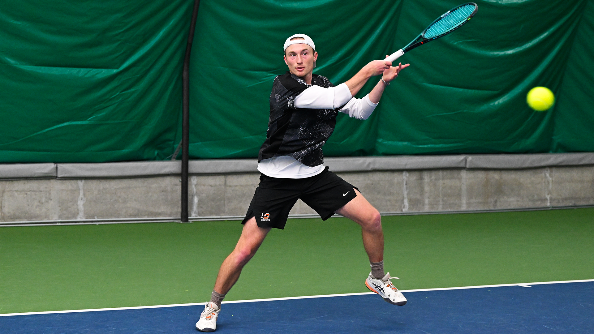 Kai Wills hits a forehand against an opponent. 
