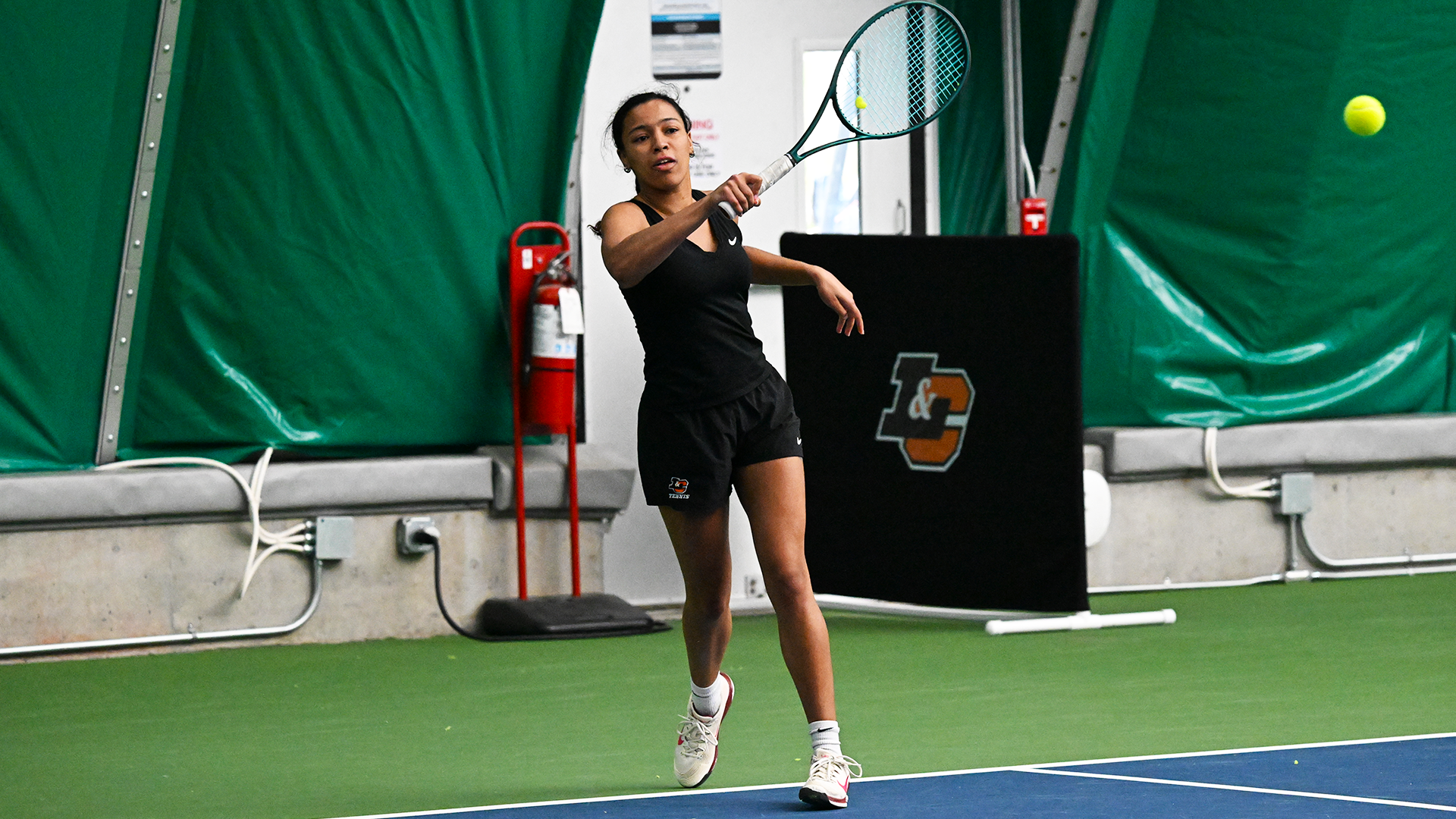 Maya Curry hits a baseline forehand