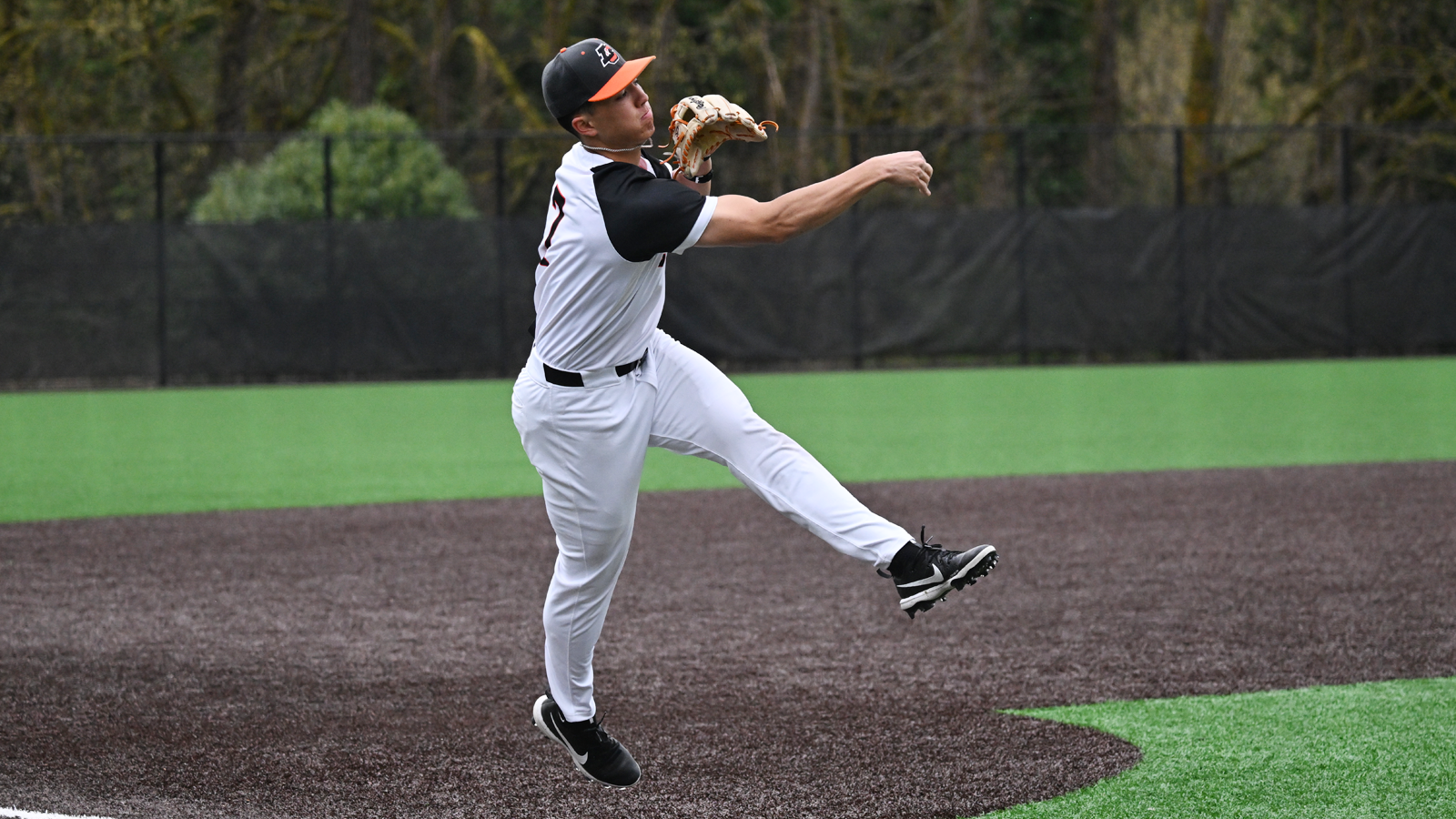 Michael Aikawa jumps and throws the ball to first base 