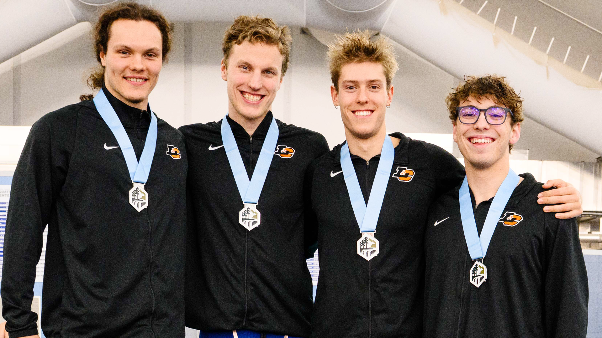The men's 400 Free Relay team poses for a photo with their medals after finishing in 2nd place at the 2026 NWC Championship Meet
