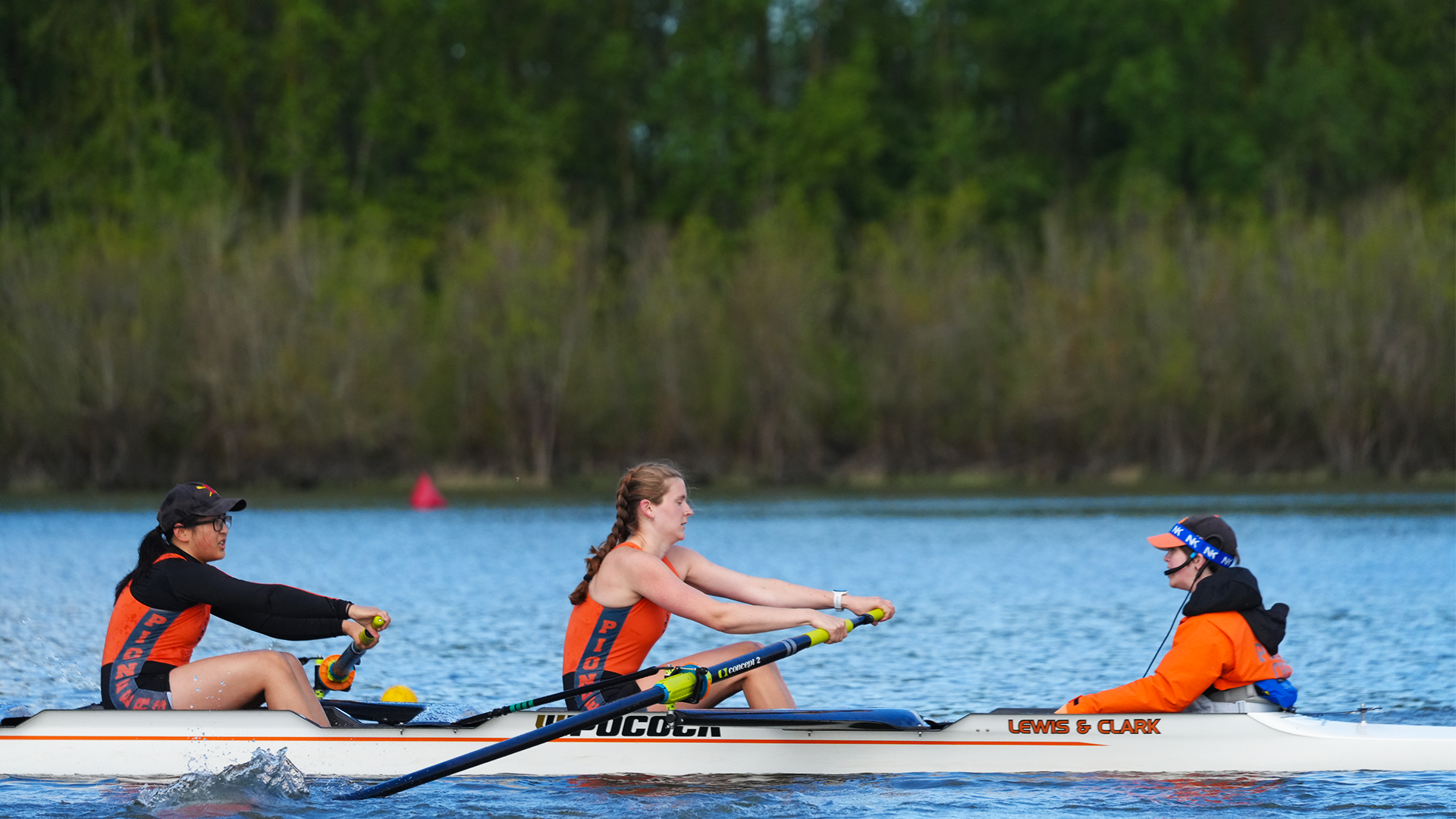 Zoe Mitchell, Sadie Meredith-Andrews, and Morgan Anderson sit in the boat during a race. 