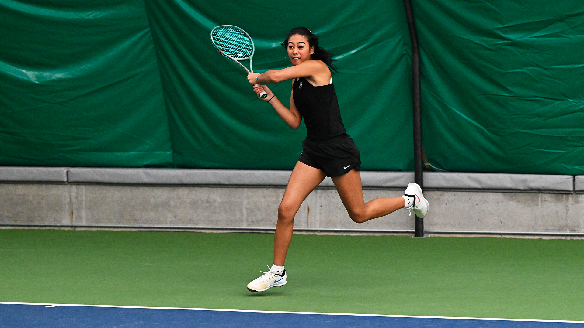Charlotte Makoni hits a baseline backhand. 