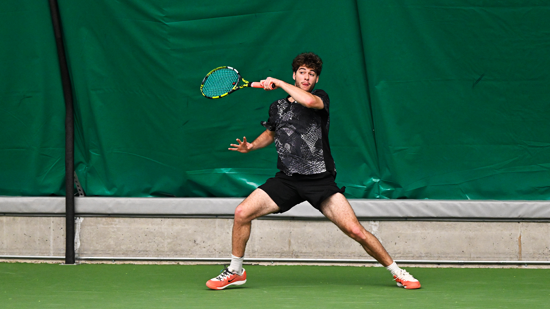 Noah Sutin hits a baseline forehand. 
