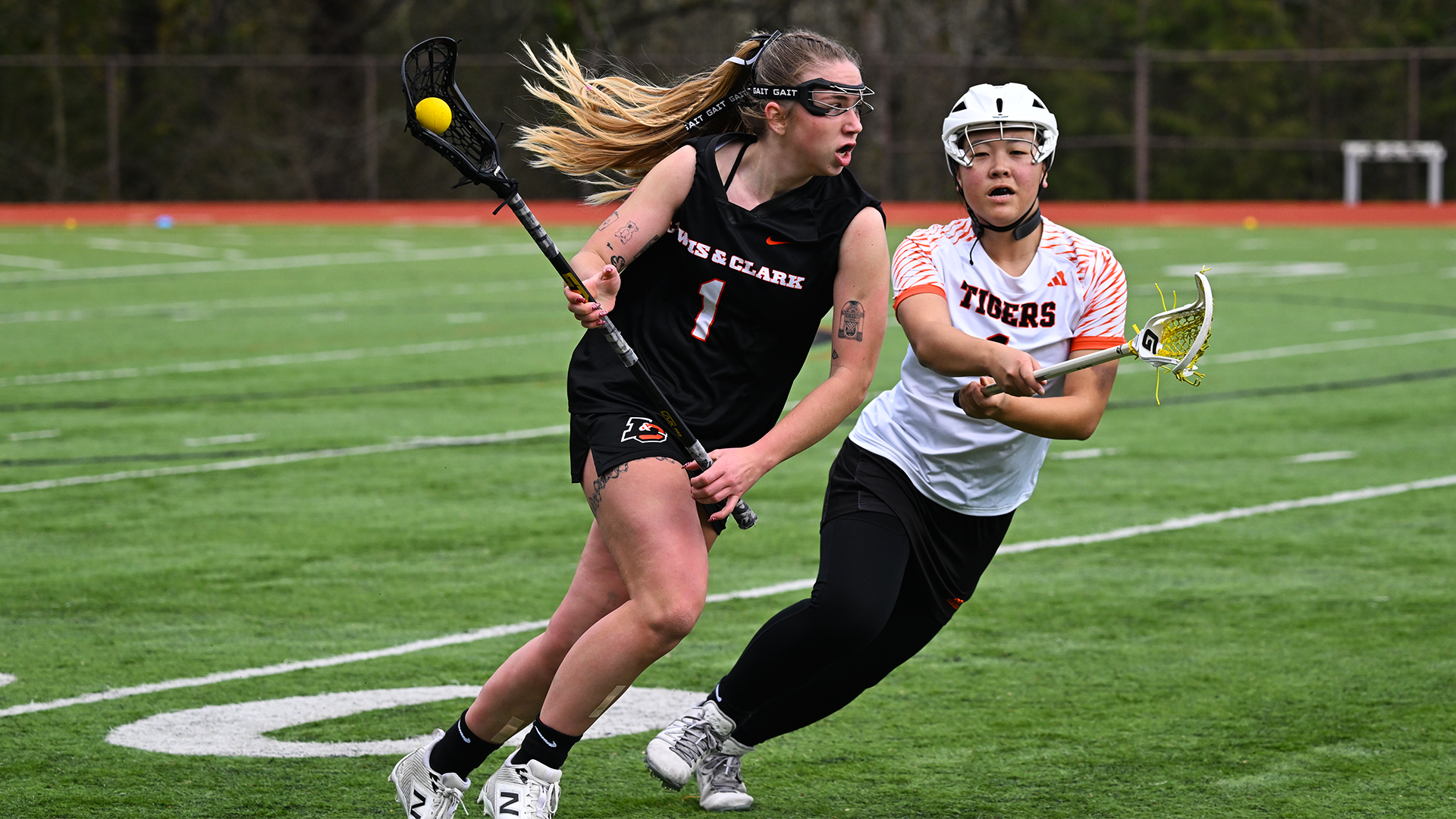 Kate Meinhard in black runs past a defender in white. 