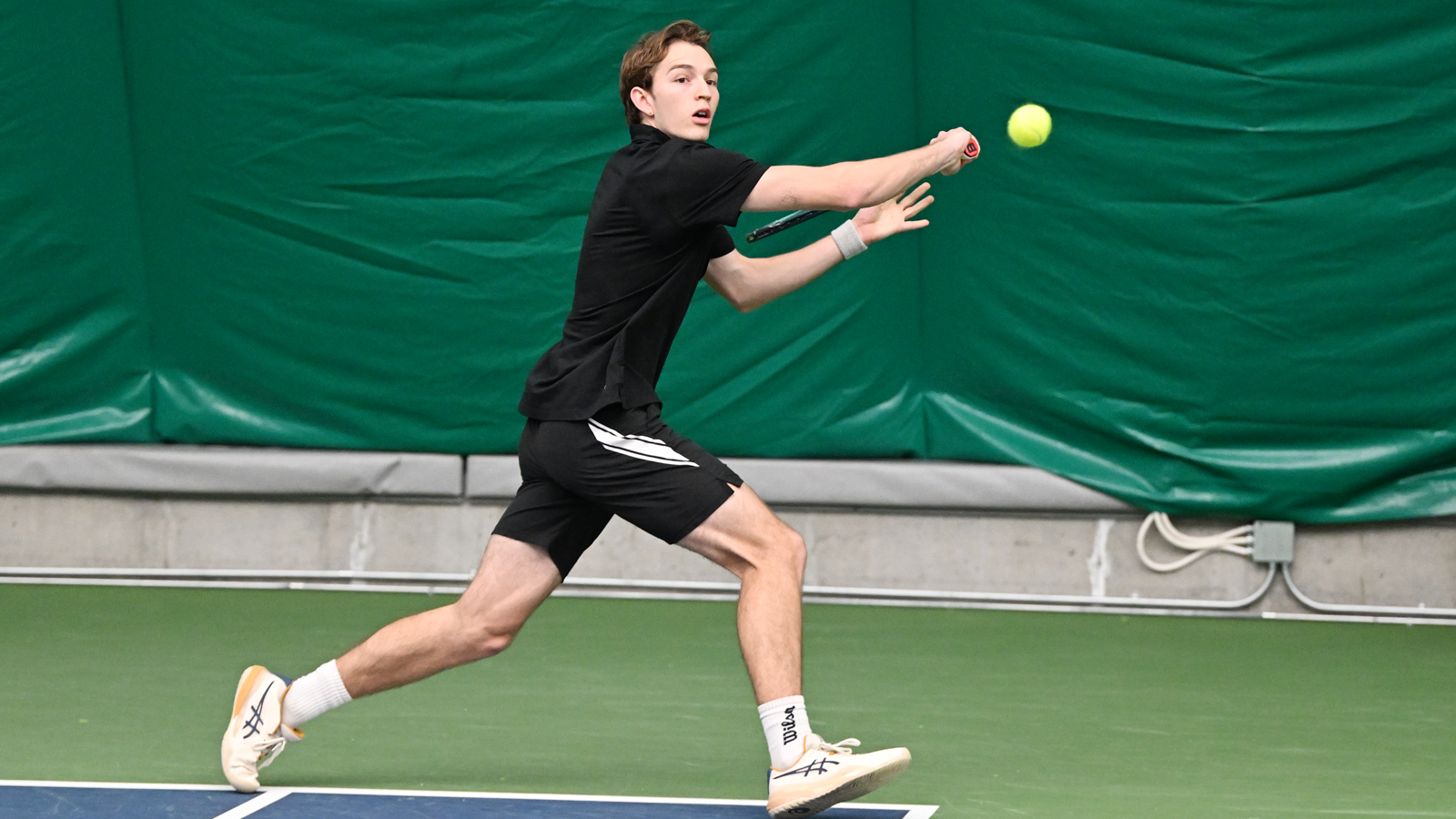 Wade McDermott runs to hit a backhand shot