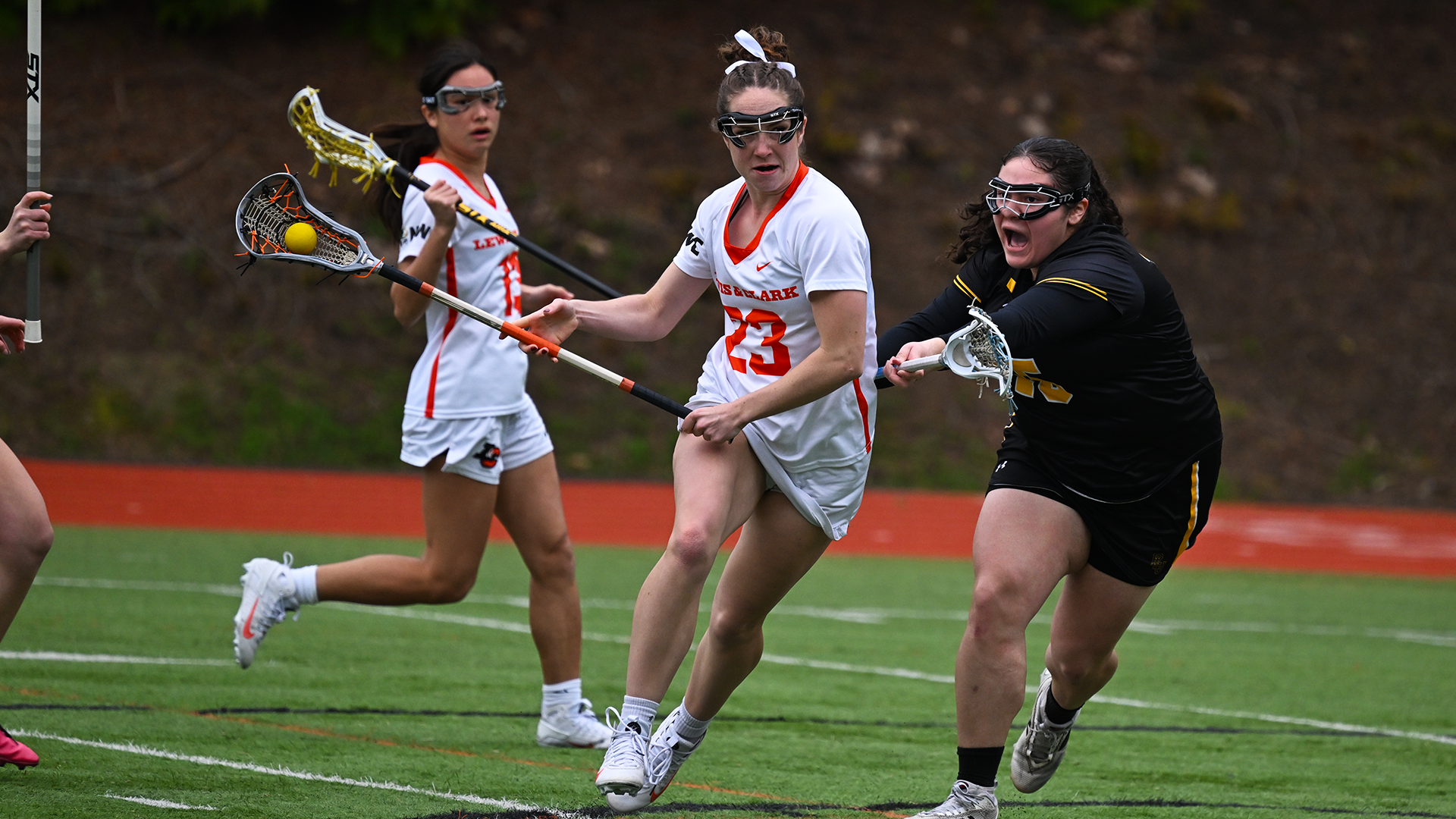Sage Swegle wearing white,  holds off a defender in black, while attempting a shot. 