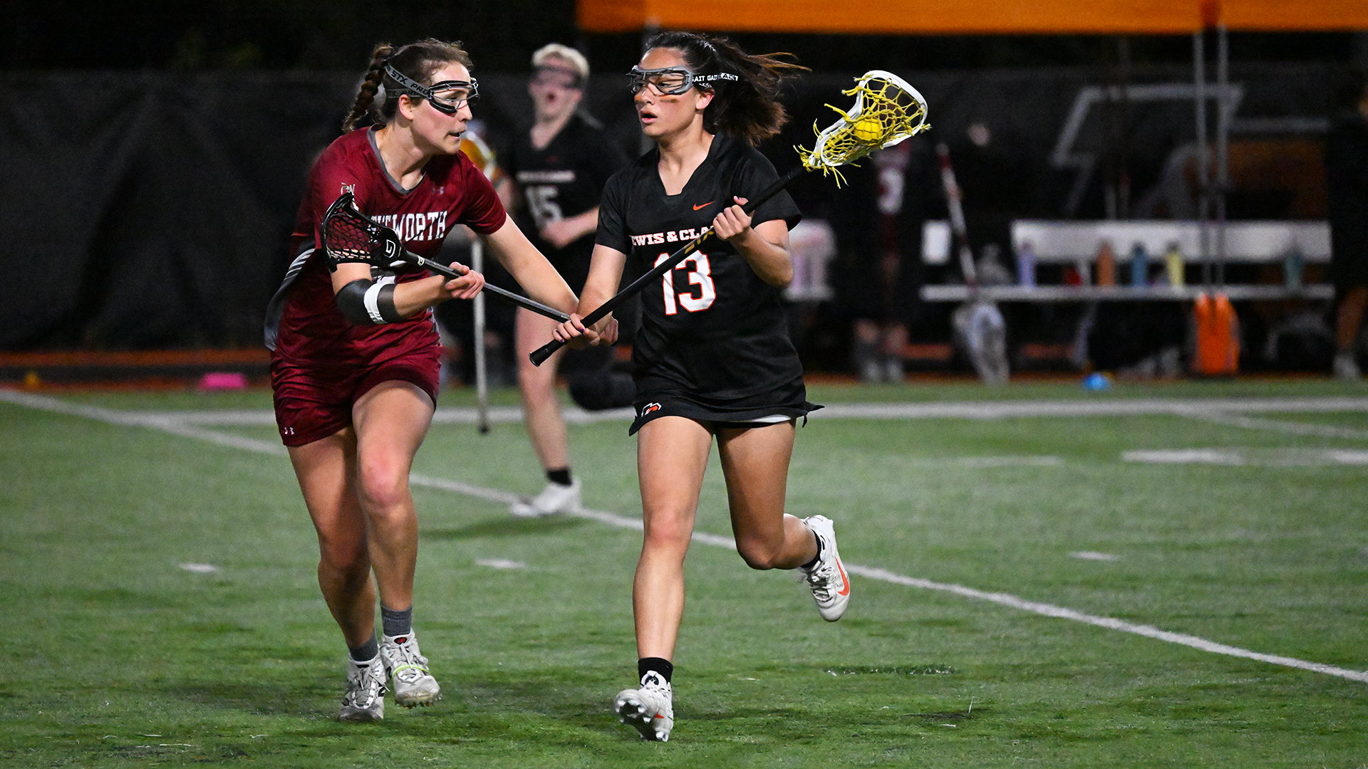 Ala Cross in black runs against a defender in red during a recent game. 